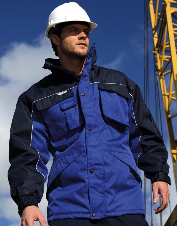 Mann mit Schutzhelm in blauer Arbeitsjacke